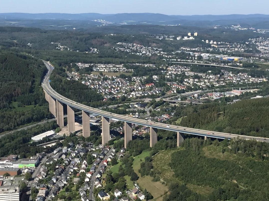 Das Bild zeigt eine Luftaufnahme der Siegtalbrücke in der Landschaft. Darunter sind Häuser zu sehen. Die Siegtalbrücke der A45 soll erneuert werden.