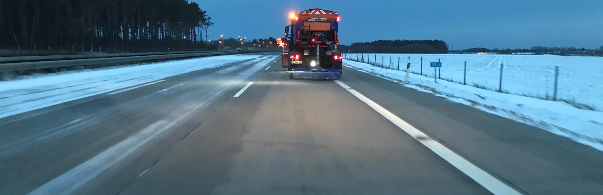 Zu abendlicher Stunde fährt ein Winterdienstfahrzeug auf dem Autobahn-Bestandnetz der Niederlassung Nord seine Tour, um die Fahrbahnen schnee- und eisfrei zu halten