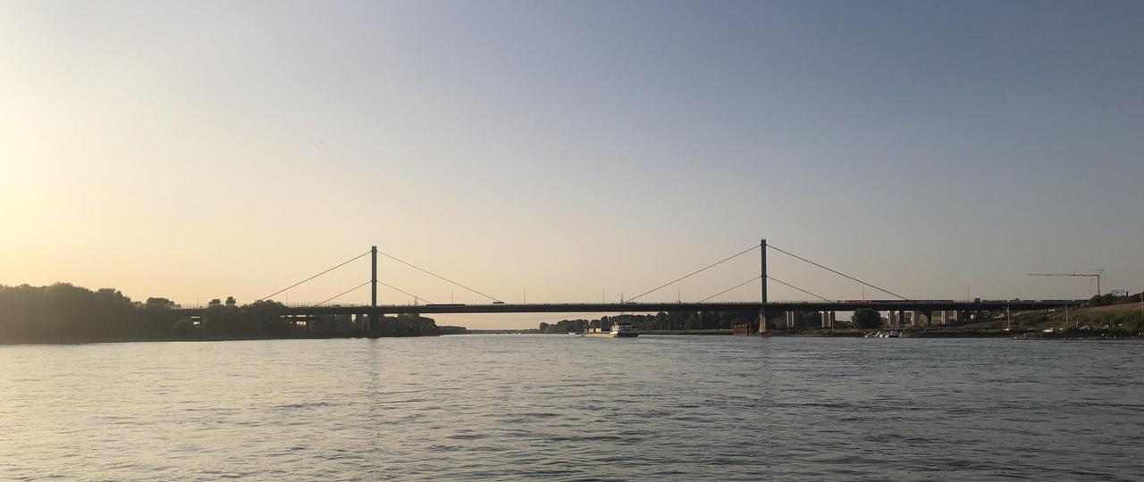 Zu sehen ist die Rheinbrücke Leverkusen aus der Ferne im Sonnenuntergang