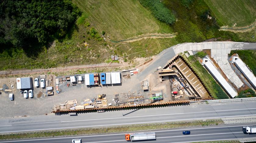 Luftbildaufnahme von der Baustelle, die zur Montage der Brücke benutzt wird.