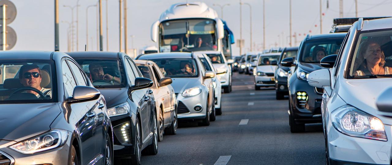 Das Bild zeigt zwei Reihen von Autos, die auf einer Autobahn im Stau stehen. 