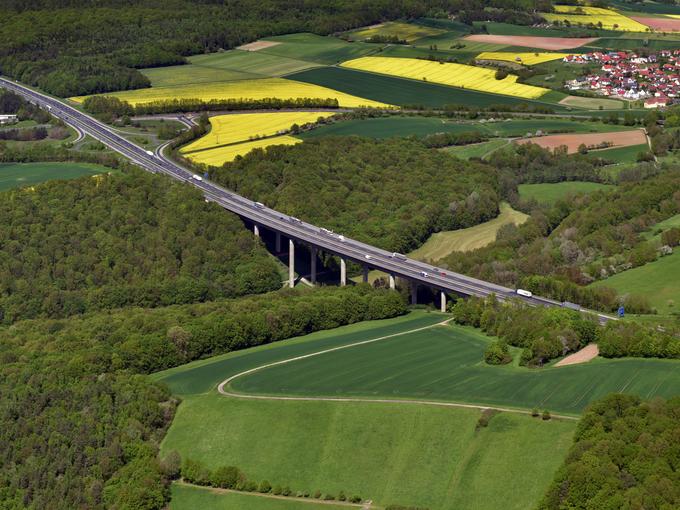 Das Bild zeigt eine Luftaufnahme mit Landschaft und der Autobahn A7 zur Erneuerung der Talbrücke Thulba
