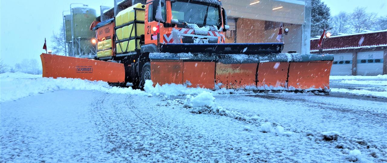 Das Bild zeigt ein Schneefahrzeug im Einsatz zur Freiräumung einer beschneiten Straße