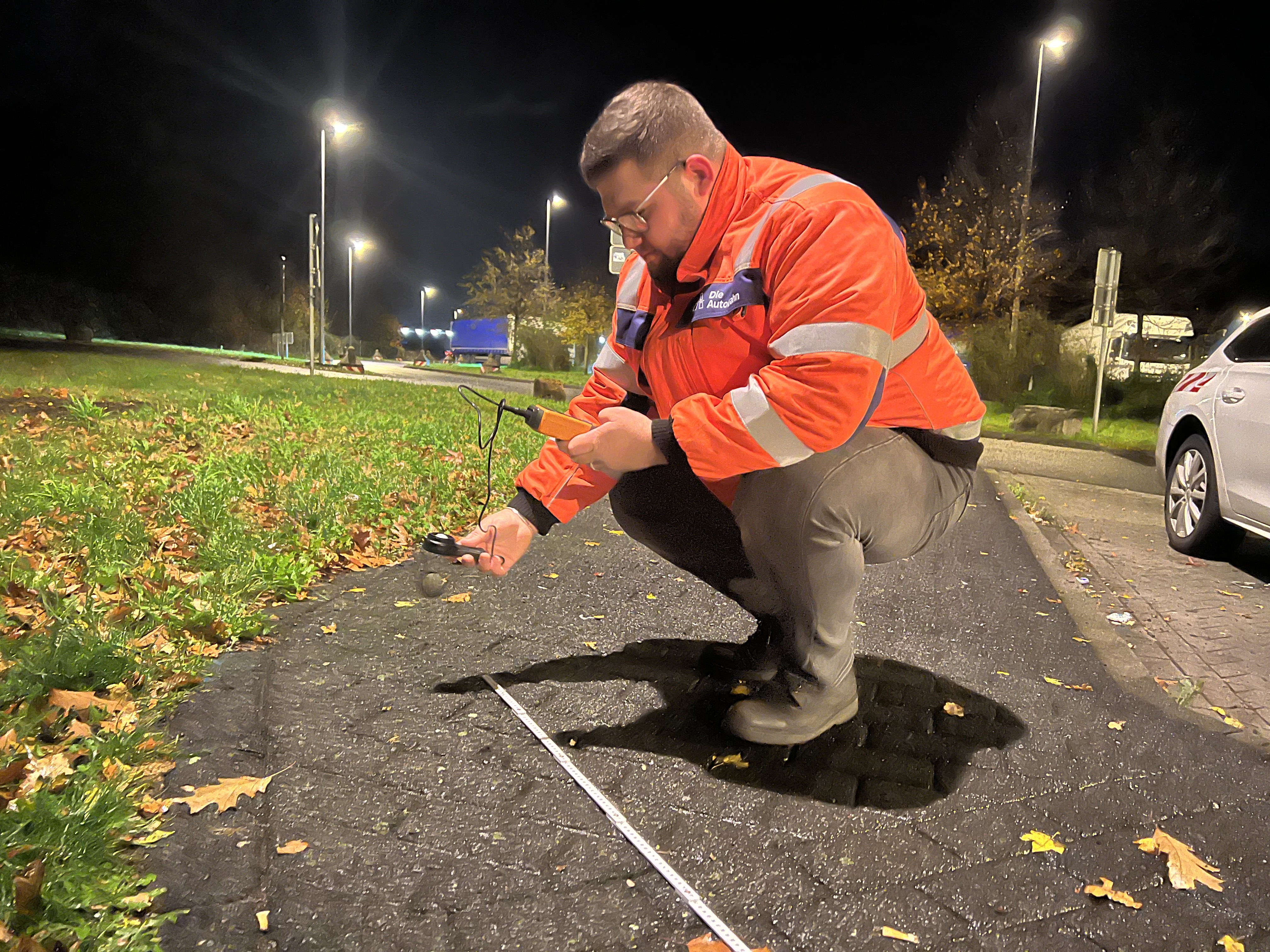 Elektroingenieur Halil Sen misst auf einem Gehweg auf der PWC-Anlage Hohenhorst die Leuchtstärke der neu aufgestellten Laternen.