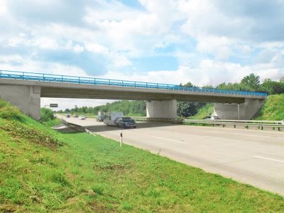 Seitlicher Blick auf das Brückenbauwerk an der Anschlussstelle Reinfeld über die A1. Der Himmel ist blau.