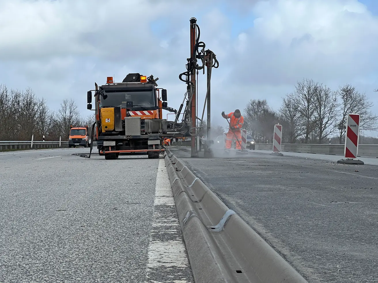 Die asphaltierten Mittelstreifen-Überfahrten bleiben für eine spätere Nutzung erhalten, werden aber mit Leitplanken geschlossen. Um die Pfosten einbauen zu können, werden mittels Trümmerbohrung Löcher in den Asphalt gebohrt – eine vergleichsweise langwierige und vor allem laute Angelegenheit. © Die Autobahn GmbH des Bundes