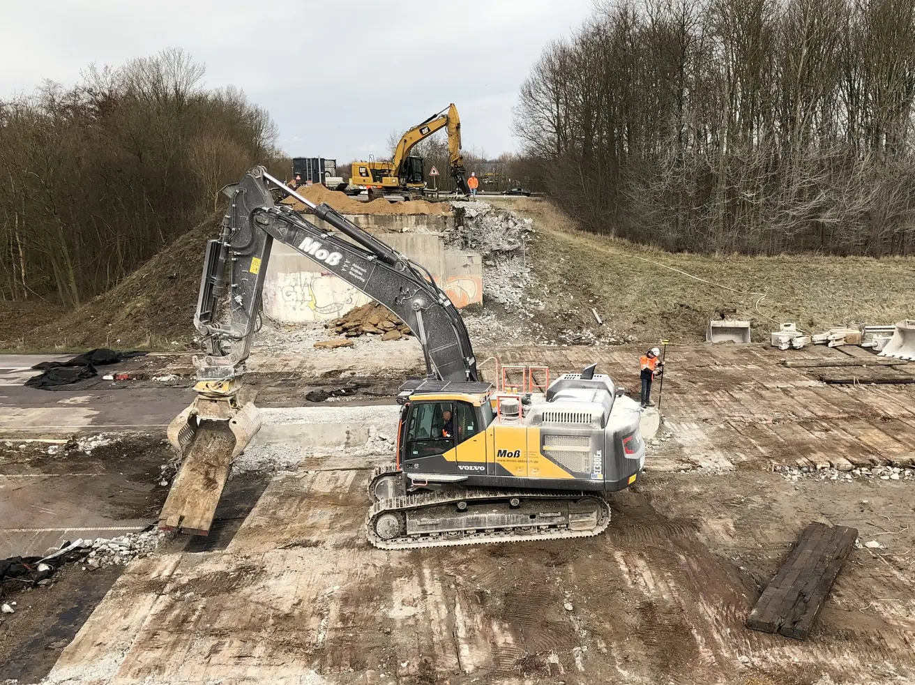 Bagger räumen die Trümmerteile des abgerissenen Brückenbauwerks weg.