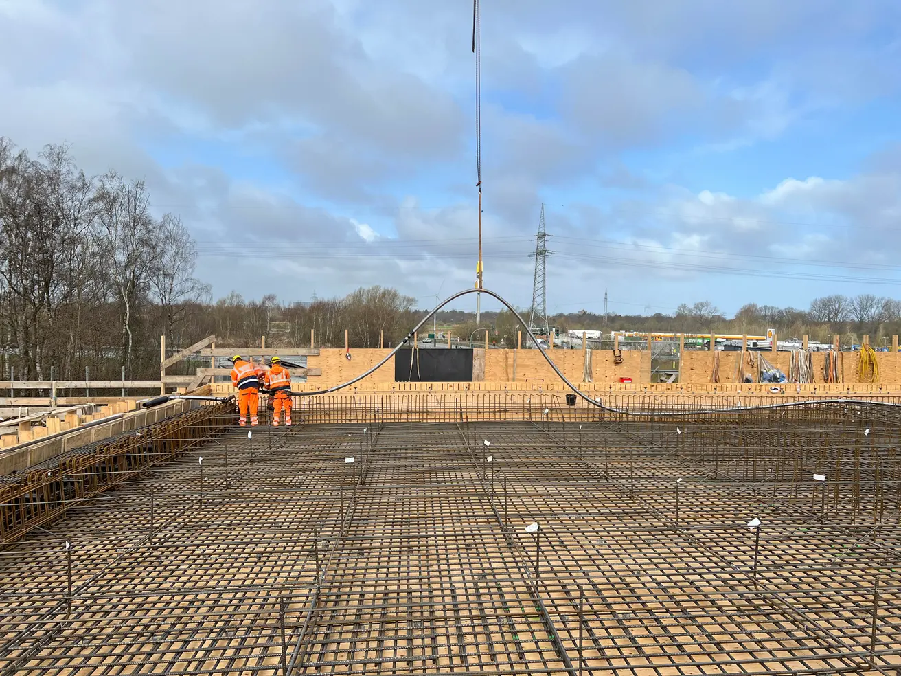 Nach dem Abrollen werden die Spannstähle noch einmal angehoben und am Überbau-Ende durch die Bewehrung und Schalung für den Querträger geschoben. © Die Autobahn GmbH des Bundes Nach dem Abrollen werden die Spannstähle noch einmal angehoben und am Überbau-Ende durch die Bewehrung und Schalung für den Querträger geschoben. © Die Autobahn GmbH des Bundes
