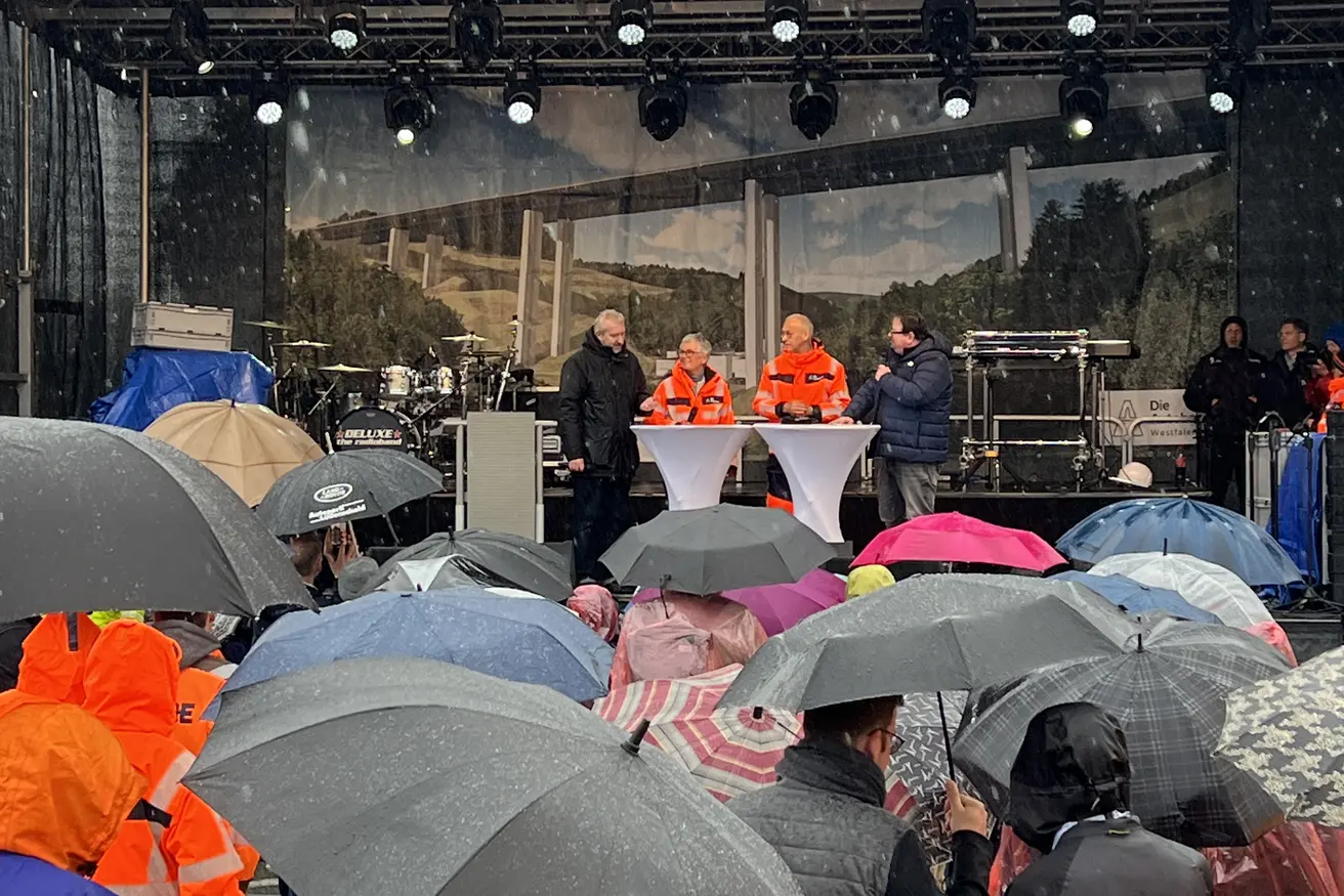 Blick auf die Bühne über Regenschirme hinweg.