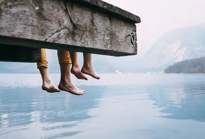 Two people sitting by a calm lake