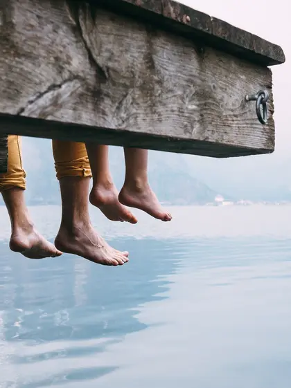 Two people sitting by a calm lake