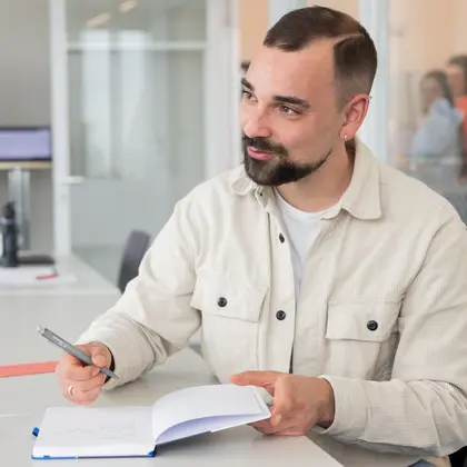 Kollege macht Notizen am Tisch