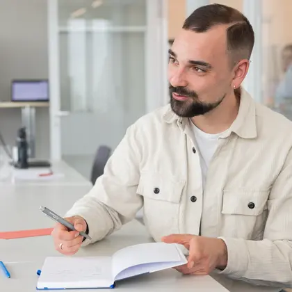 Kollege macht Notizen am Tisch