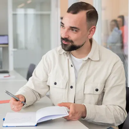 Kollege macht Notizen am Tisch