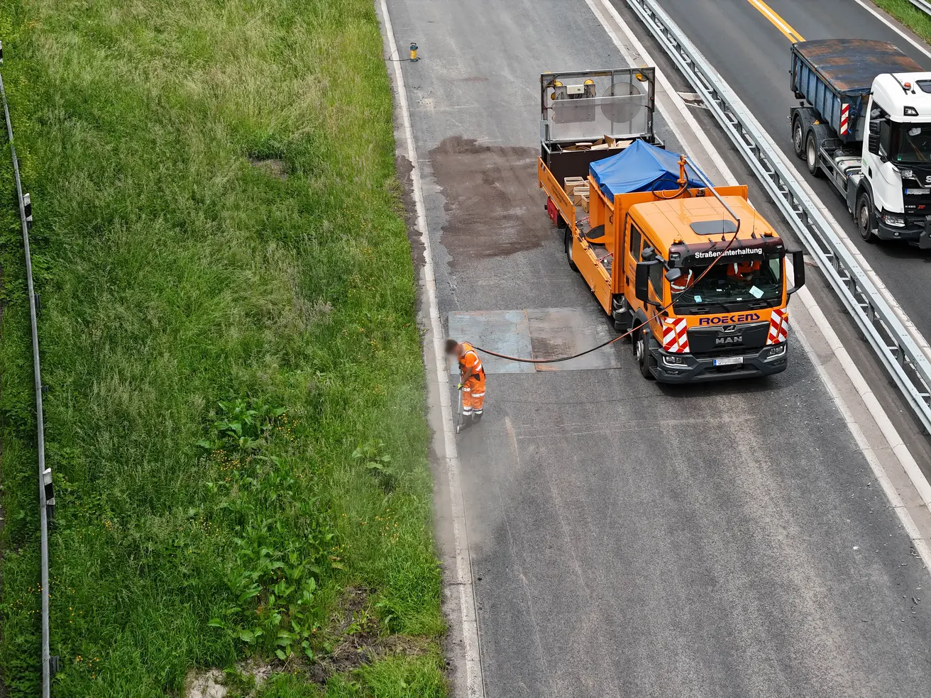 Zu den Betonrandsteinen hin wird eine Fuge in den Asphalt geschnitten. Das Foto zeigt ihr Säuberung von Staub und Steinchen direkt vor dem Abdichten durch Vergießen. © Die Autobahn GmbH des Bundes