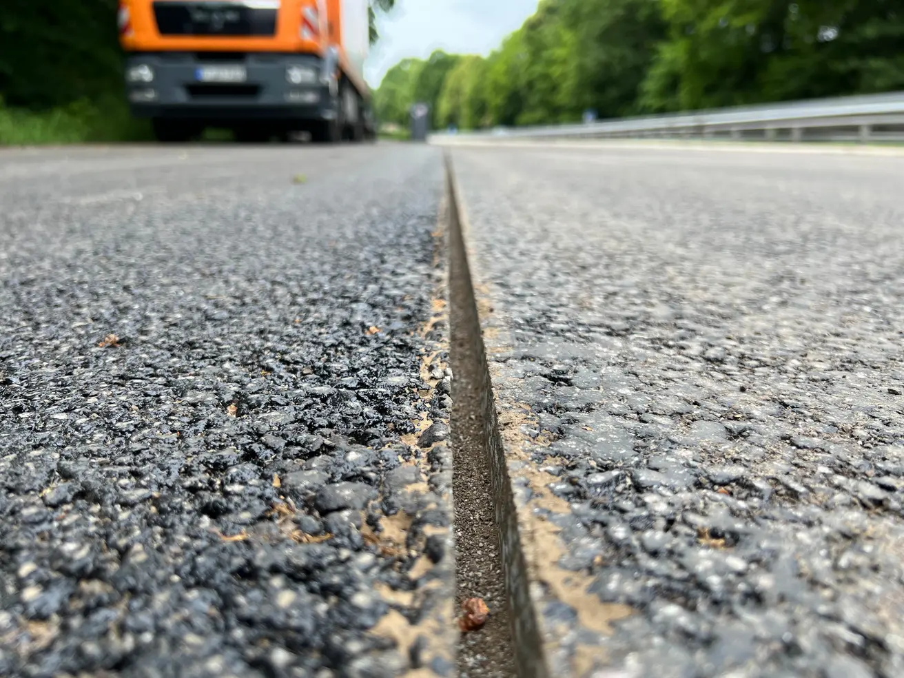 Diese Fuge in der Deckschicht des Asphalts wurde geschnitten, weil hier im Bereich einer Auffahrt zwei nacheinander asphaltierte Stellen aneinanderstoßen. Der anschließende Verguss der Fuge garantiert, dass später keine Feuchtigkeit an der Nahtstelle eindringt. © Die Autobahn GmbH des Bundes