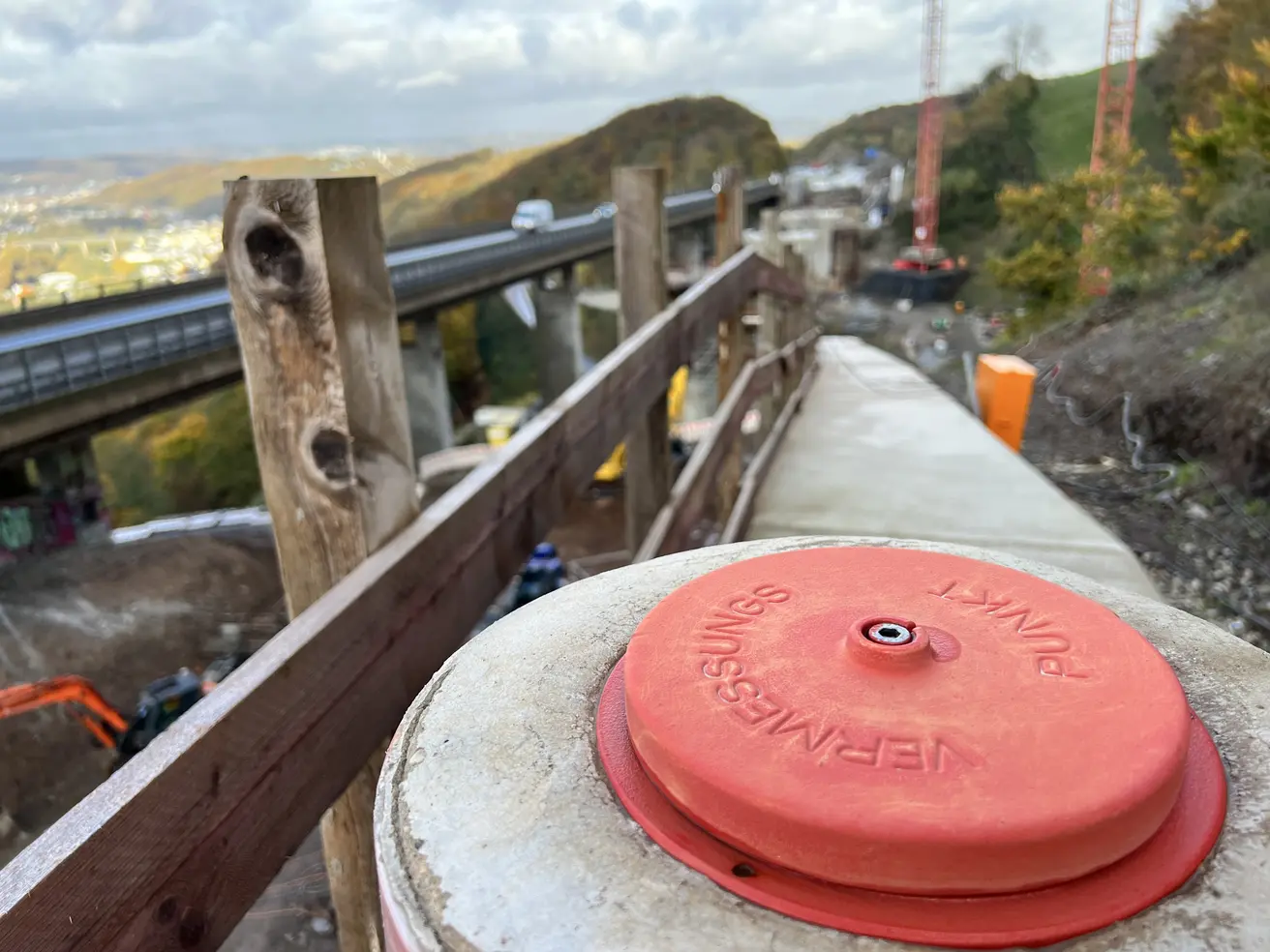 Vermessungspunkt, im Hintergrund die Baustelle