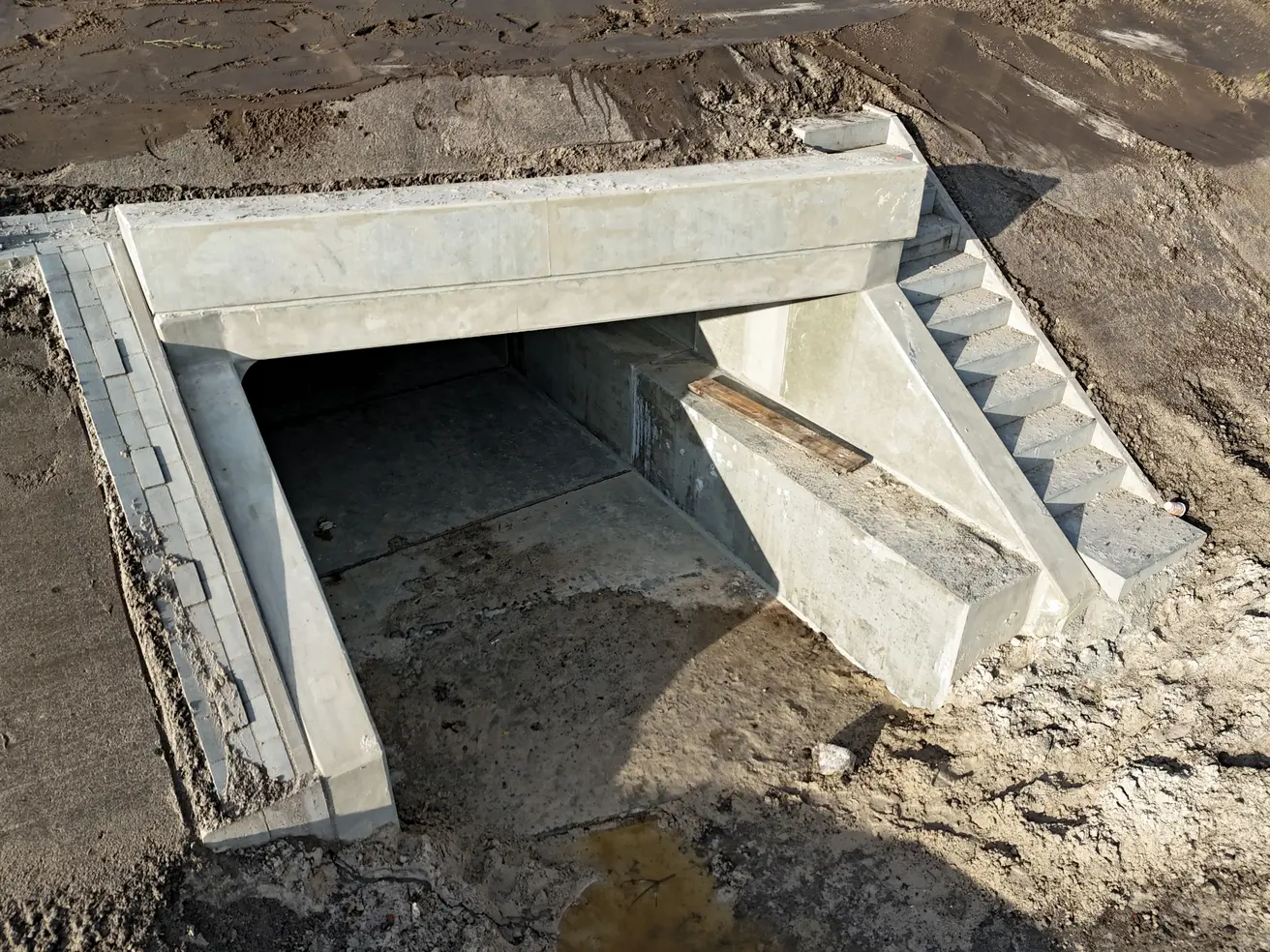 Der östliche Ausgang des neuen Durchlasses mit Böschungstreppe (rechts) und Rinne (links). © Die Autobahn GmbH des Bundes